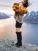 The Wild Muse fox fur coat in cherry red and gray, styled in motion on a mountain ledge, perfect for luxury winter outerwear.