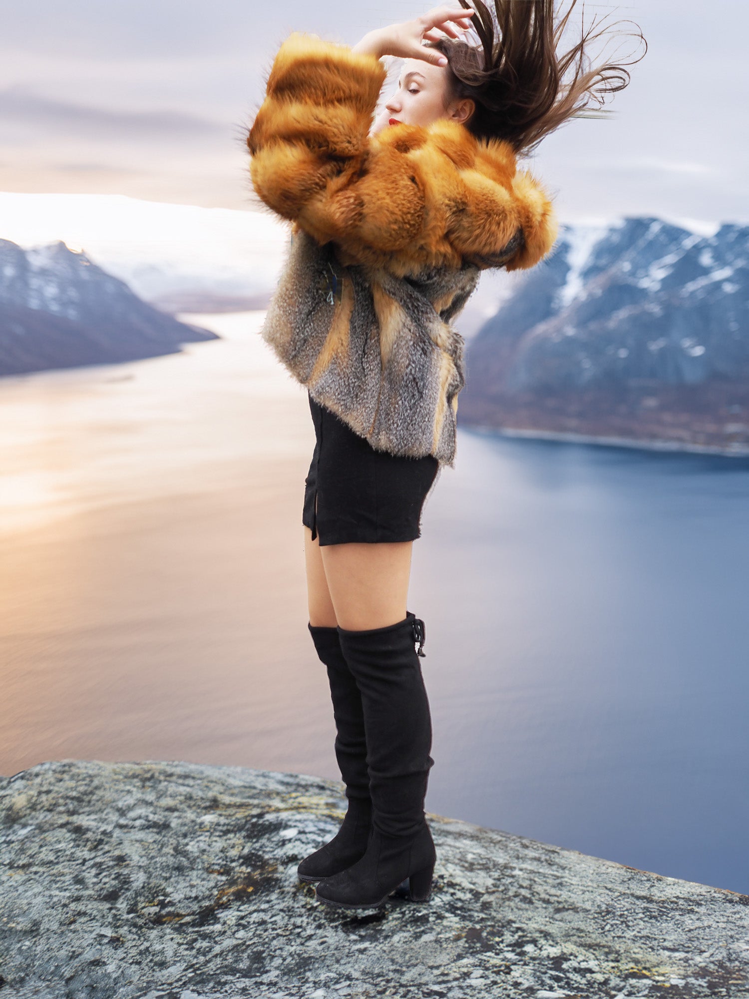 The Wild Muse fox fur coat in cherry red and gray, styled in motion on a mountain ledge, perfect for luxury winter outerwear.