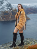 Luxury red gray fox fur coat by The Wild Muse, styled on a cliff edge with snowy peaks, showcasing its bold fur fashion appeal.
