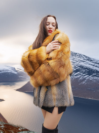 The Wild Muse red gray fox fur coat with voluminous sleeves and shawl collar, styled in a dramatic mountain landscape for luxury outerwear appeal.