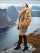Luxury red gray fox fur coat by The Wild Muse, modeled with joyful expression on a cliffside, perfect for cinematic winter fashion.