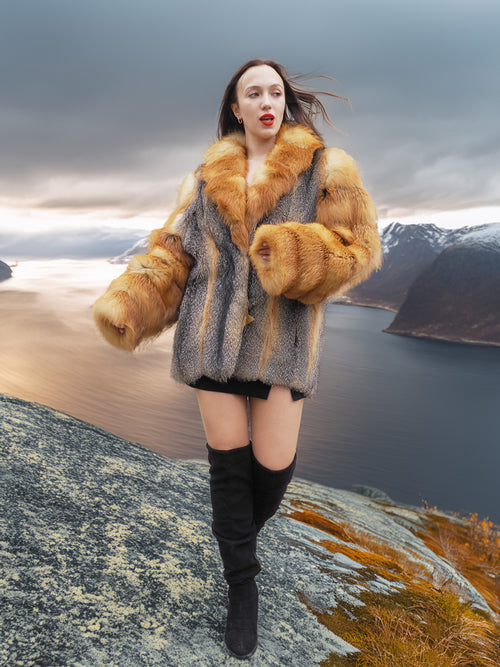 The Wild Muse fox fur coat with dramatic sleeves and collar, styled in a stormy mountain scene for a high-fashion outerwear look.