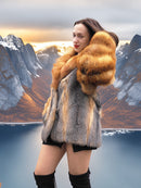 Cherry red and gray fox fur coat by The Wild Muse, worn in a golden hour fjord setting, highlighting its luxurious fur craftsmanship.
