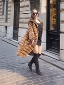 Harlow pastel mink coat with shawl collar styled open, flowing naturally while walking in a city street setting.