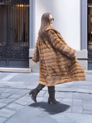 Harlow pastel mink shawl collar coat twirling mid-motion, highlighting its full silhouette and rich striped mink texture.