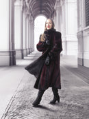 Model poses under archway in red and black mink fur coat, highlighting timeless elegance and fur craftsmanship.
