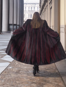 Back view of red and black mink fur coat flared open, showing dramatic chevron pattern and full-length design.