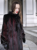 Close-up of red and black mink fur coat showing detailed texture and elegant pattern, perfect for cold-weather luxury outerwear.