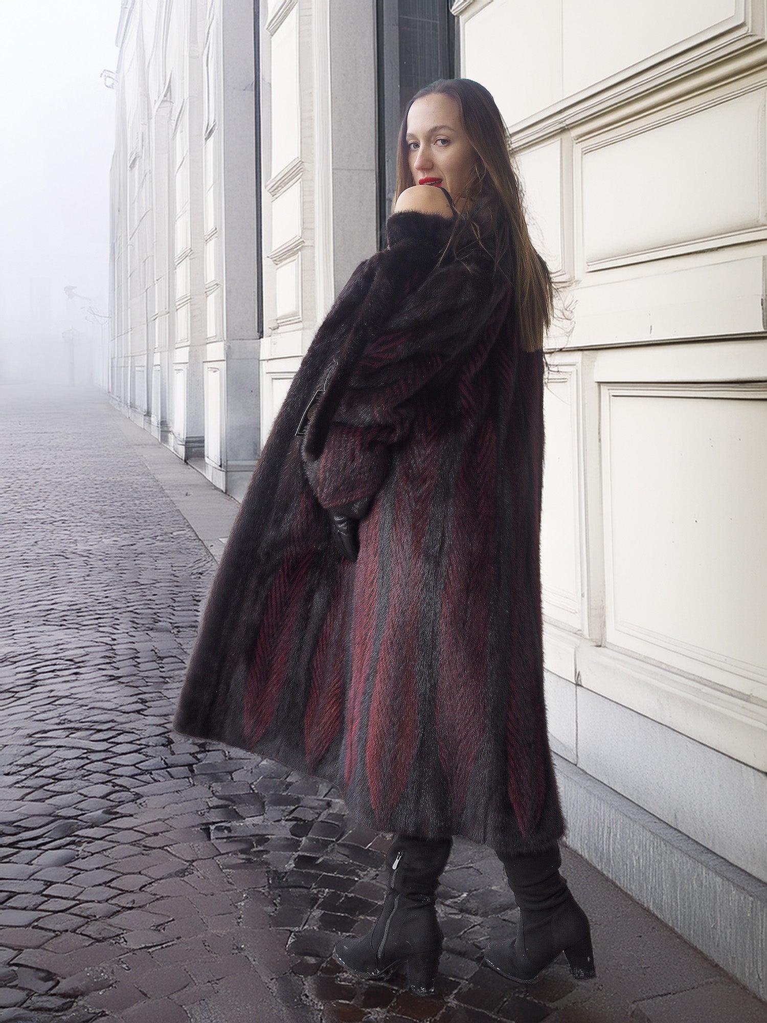 Model glances over shoulder in red and black mink fur coat, showcasing sustainable and stylish winter outerwear.