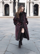 Model walks confidently in red and black mink fur coat, highlighting its unique two-tone design and luxurious texture.