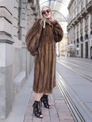 Elegant woman in luxurious vintage Canadian brown mink fur coat with silk lining, walking on city street.
