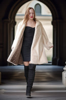 Pearl mink swing coat with hood, cream fur drape over dark mini dress and boots