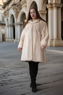 Cream mink coat with wide swing silhouette and plush collar; long sleeves