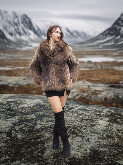 Raccoon Glamour Jacket - Mountain Mirage S/M paired with black mini dress and boots, set against dramatic alpine backdrop for luxury outerwear appeal.