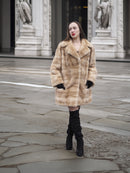 Luxury blond pastel mink fur coat stroller jacket paired with thigh-high boots, showcasing warm and stylish cold-weather outerwear.