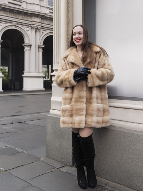 Model posing in blond pastel mink fur coat stroller jacket with gloves, perfect for luxury outerwear and cold-weather fashion.