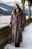 Long raccoon fur double-breasted coat with notched lapels and silver button front