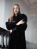 Woman wearing a black fur coat in an elegant interior setting