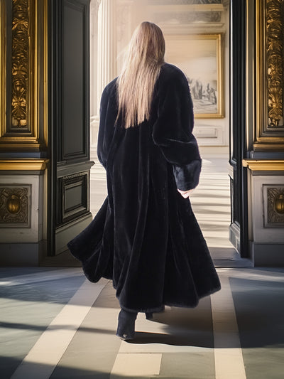 Person in a long black coat walking through an ornate doorway in a museum.