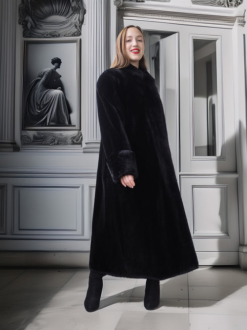 Woman wearing a long black coat in an elegant interior setting