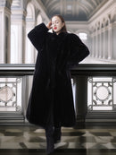 Woman wearing a black coat in an elegant interior setting