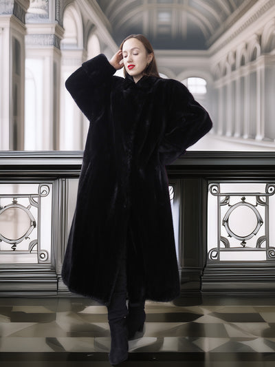 Woman wearing a black coat in an elegant interior setting