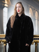 Woman wearing a black fur coat in an elegant interior setting
