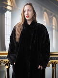 Woman wearing a black fur coat in an elegant interior setting