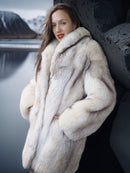 Woman wearing a fur coat with a snowy landscape in the background