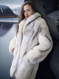 Woman wearing a fur coat with a snowy landscape in the background