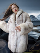 Woman wearing a fur coat with a snowy mountain landscape in the background