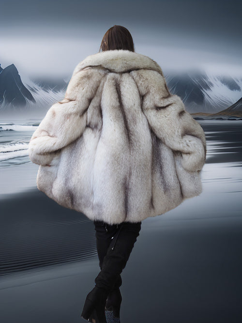 Person wearing a fur coat with a mountainous landscape in the background