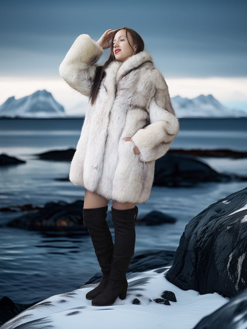 Woman in a fur coat standing on a snowy landscape with mountains in the background