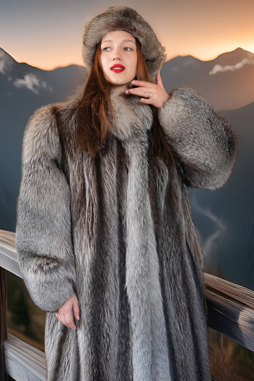 Person wearing a fur coat and hat with a mountainous background