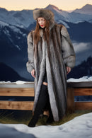 Woman wearing a fur coat and hat in a snowy mountain setting
