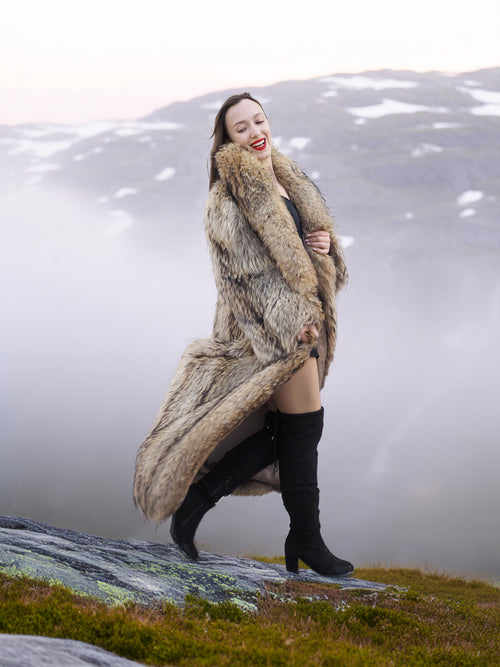 Flowing Finnish Raccoon Fur Coat in motion, styled with black dress and boots, ideal for luxury winter fashion in misty mountains.