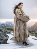 Side view of Finnish Raccoon Fur Coat with natural brown tones and shawl collar, worn in snowy mountain landscape.