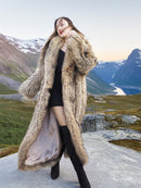 Model posing in Finnish Raccoon Fur Coat with large shawl collar, styled in mountainous terrain for sustainable winter outerwear.