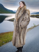 Full-length Finnish Raccoon Fur Coat with thick collar and natural fur texture, worn near a calm lake in winter setting.