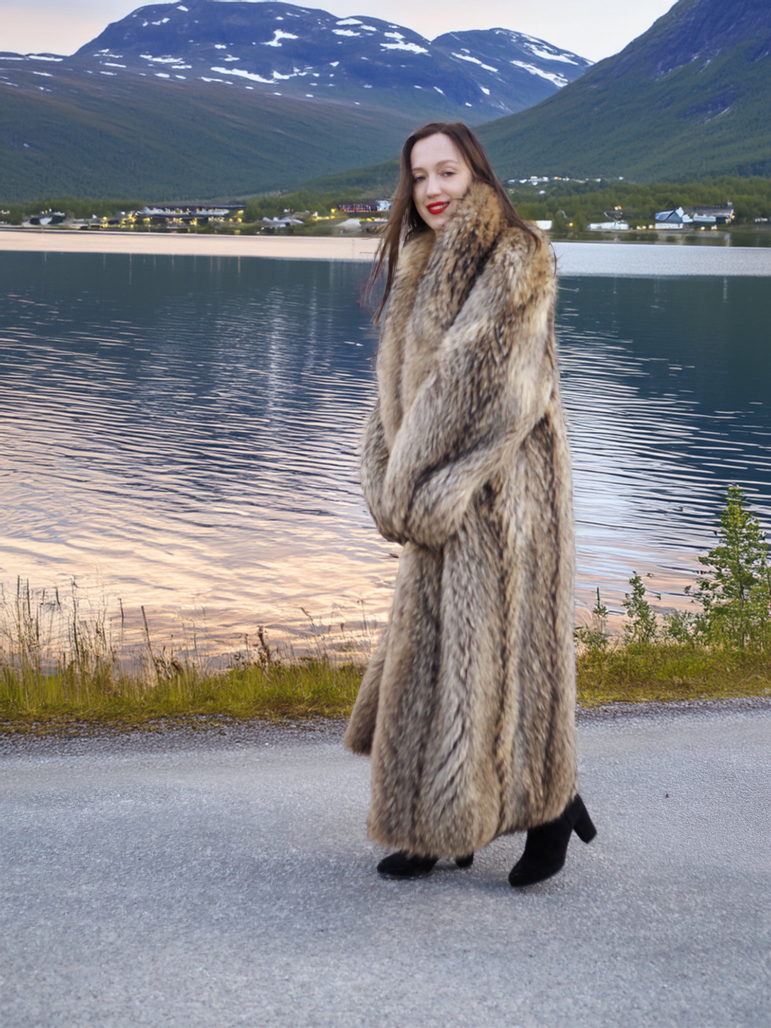 Warm Finnish Raccoon Fur Coat 50" long with voluminous shawl collar, worn outdoors near a lake with mountain backdrop.
