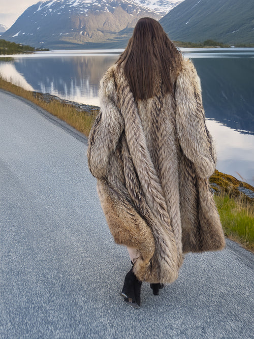 Rear view of Finnish Raccoon Fur Coat with natural fur pattern and shawl collar, worn on scenic lakeside road.