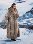 Model walking in snow wearing Finnish Raccoon Fur Coat with thick collar and full-length design, ideal for winter warmth.