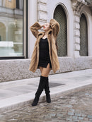 Golden Reverie M - Mink coat worn open with arms raised, showcasing golden interior and luxurious fur texture.