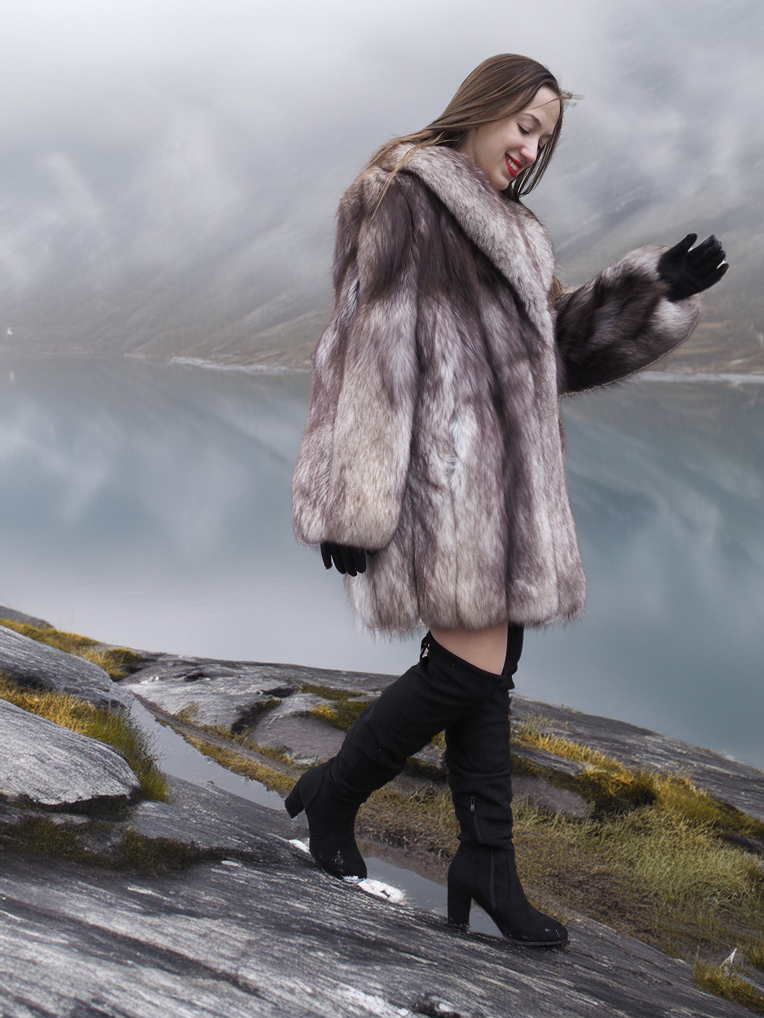 Soft and fluffy blue fox fur coat with oversized collar, worn while walking on rocky terrain. Real fur jacket for elegant winter fashion.
