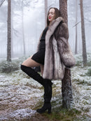 Plush blue fox fur coat with thick collar and soft pelts, modeled in a snowy forest. Elegant winter outerwear for luxury fashion lovers.