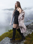 Elegant blue fox fur coat with voluminous shape and satin lining, worn on a misty mountain ledge. Premium outerwear for cold climates.