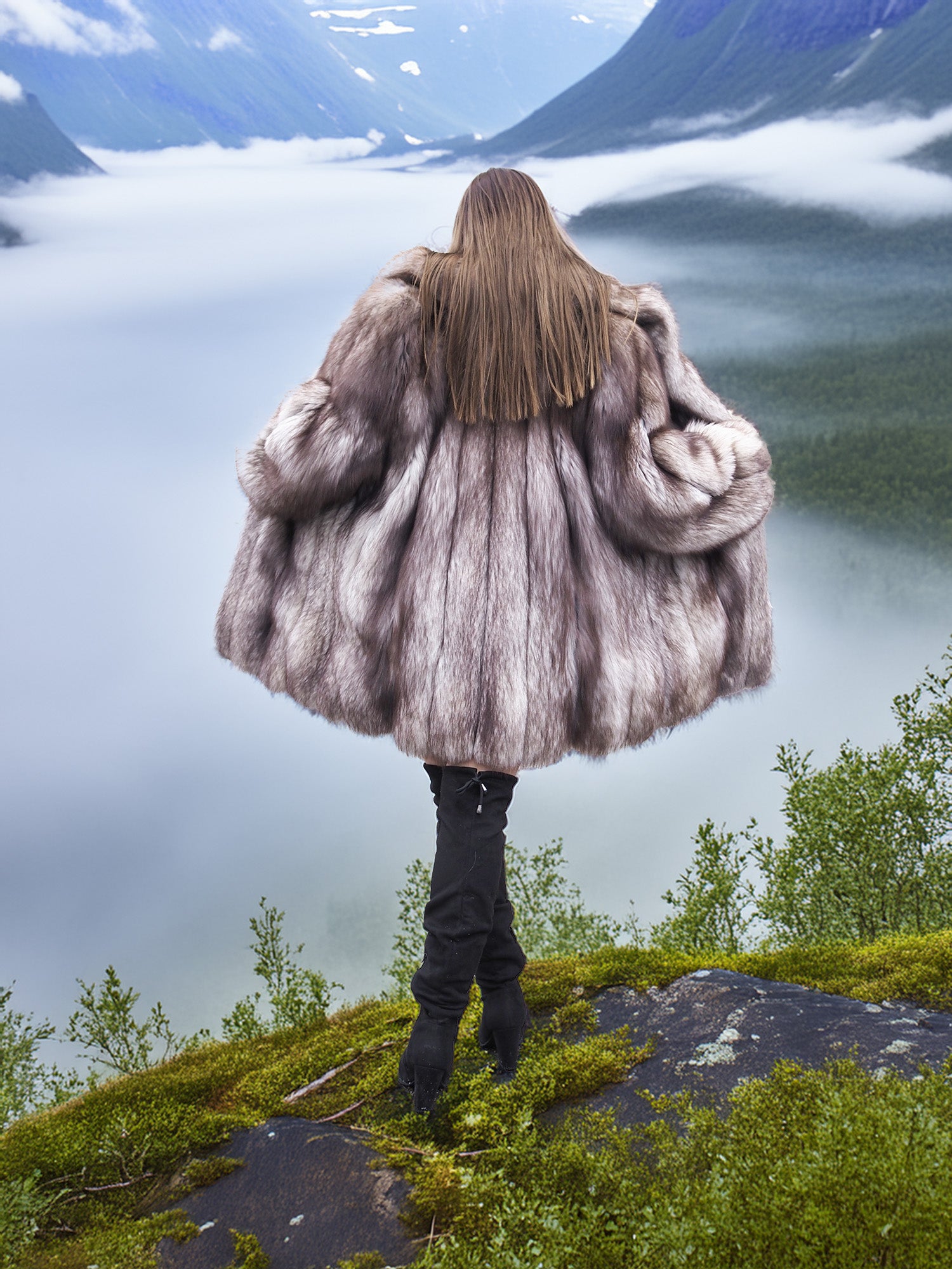Real fur blue fox coat with voluminous back and natural silver tones, modeled on a mountain ledge. Elegant winter fashion outerwear.