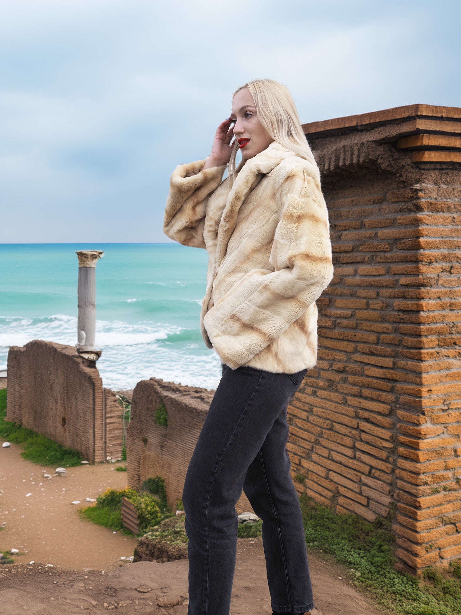 Reversible Versatile Sheared Mink Fur Jacket Coat S in plush mink fur, modeled with hands in pockets near coastal ruins.