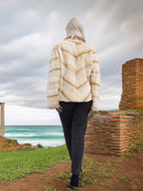 Back view of Reversible Versatile Sheared Mink Fur Jacket Coat S showing chevron fur pattern, styled near ocean cliffs and ruins.