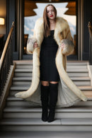 Golden fox fur coat on open stairs; voluminous full-length coat and gray cuffs